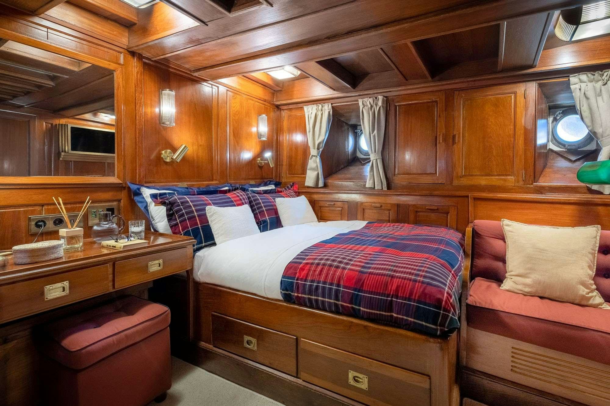 a room with wooden furniture aboard WEATHER BIRD Yacht for Charter