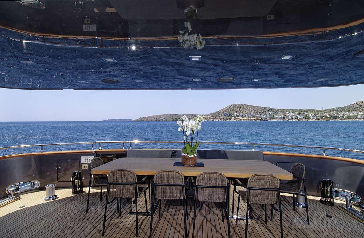 a table with chairs and a view of the ocean aboard NOEMA Yacht for Charter