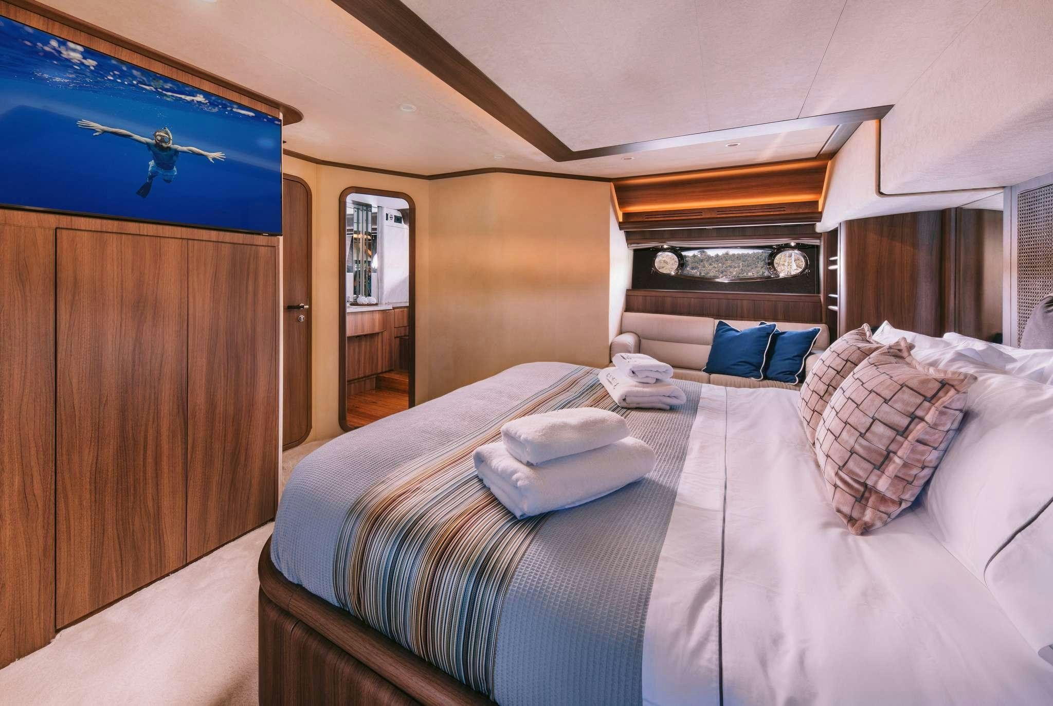 a bed with a blue and white comforter and pillows aboard OXYGEN 8 Yacht for Charter