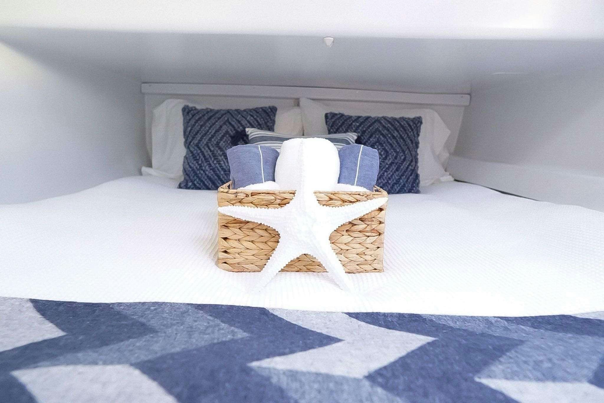 a bed with a white bed spread aboard GAIA Yacht for Charter