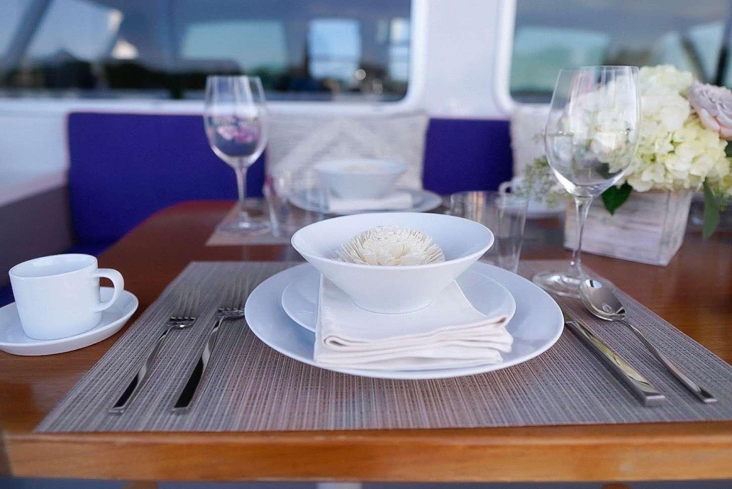 a table with a plate of food and glasses on it aboard GAIA Yacht for Charter