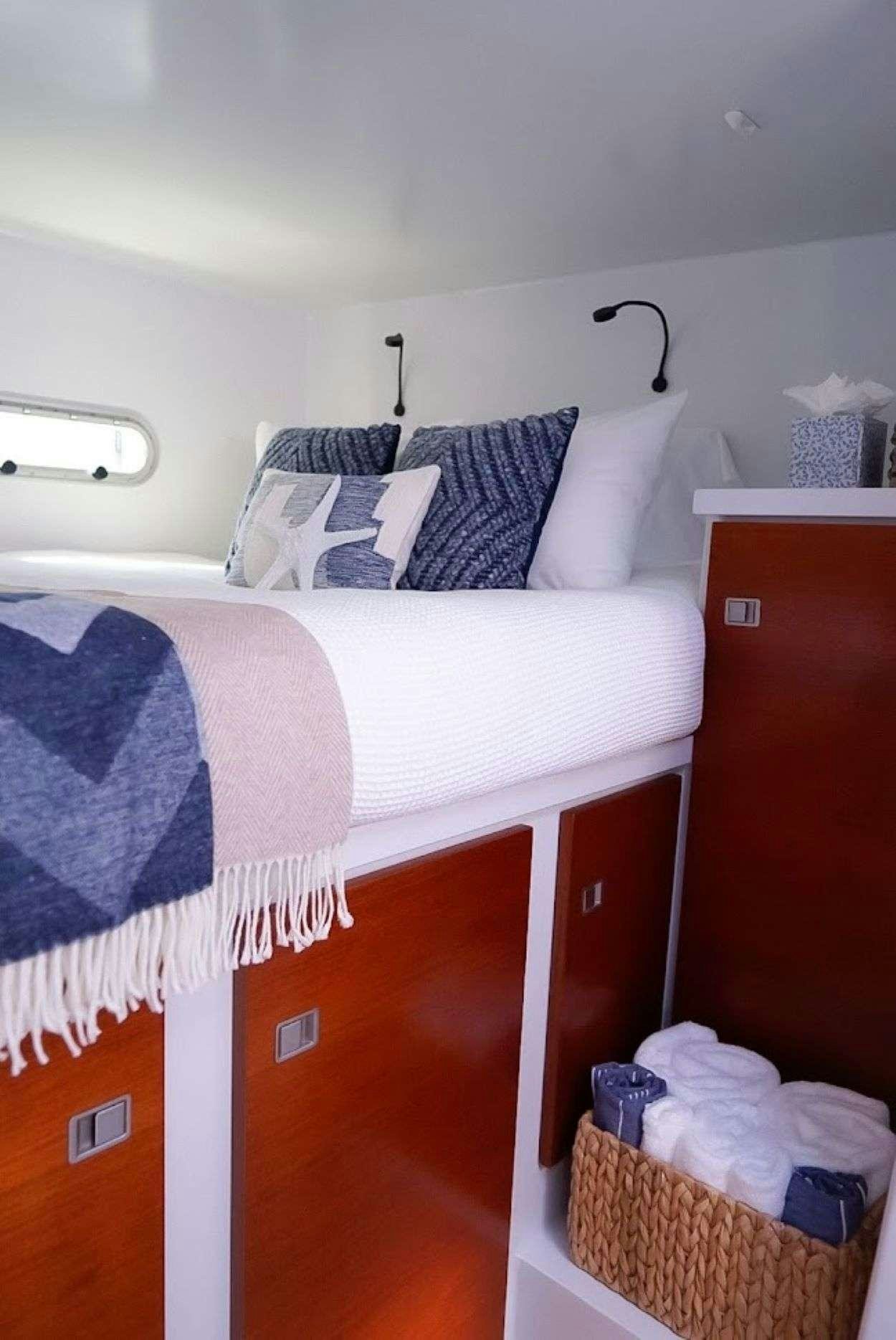 a bed with a blue blanket aboard GAIA Yacht for Charter