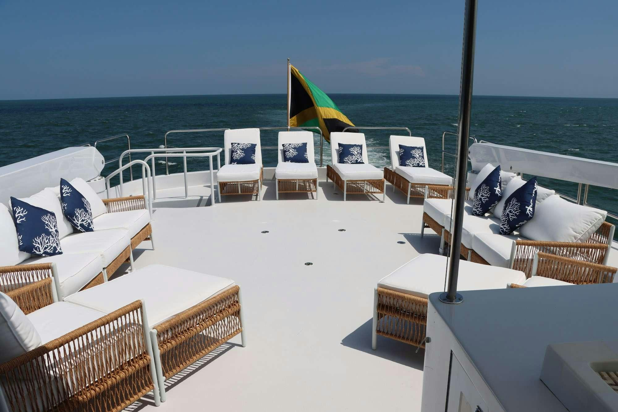 a lounge area with chairs and umbrellas on a sunny day aboard TOO SHALLOW Yacht for Charter