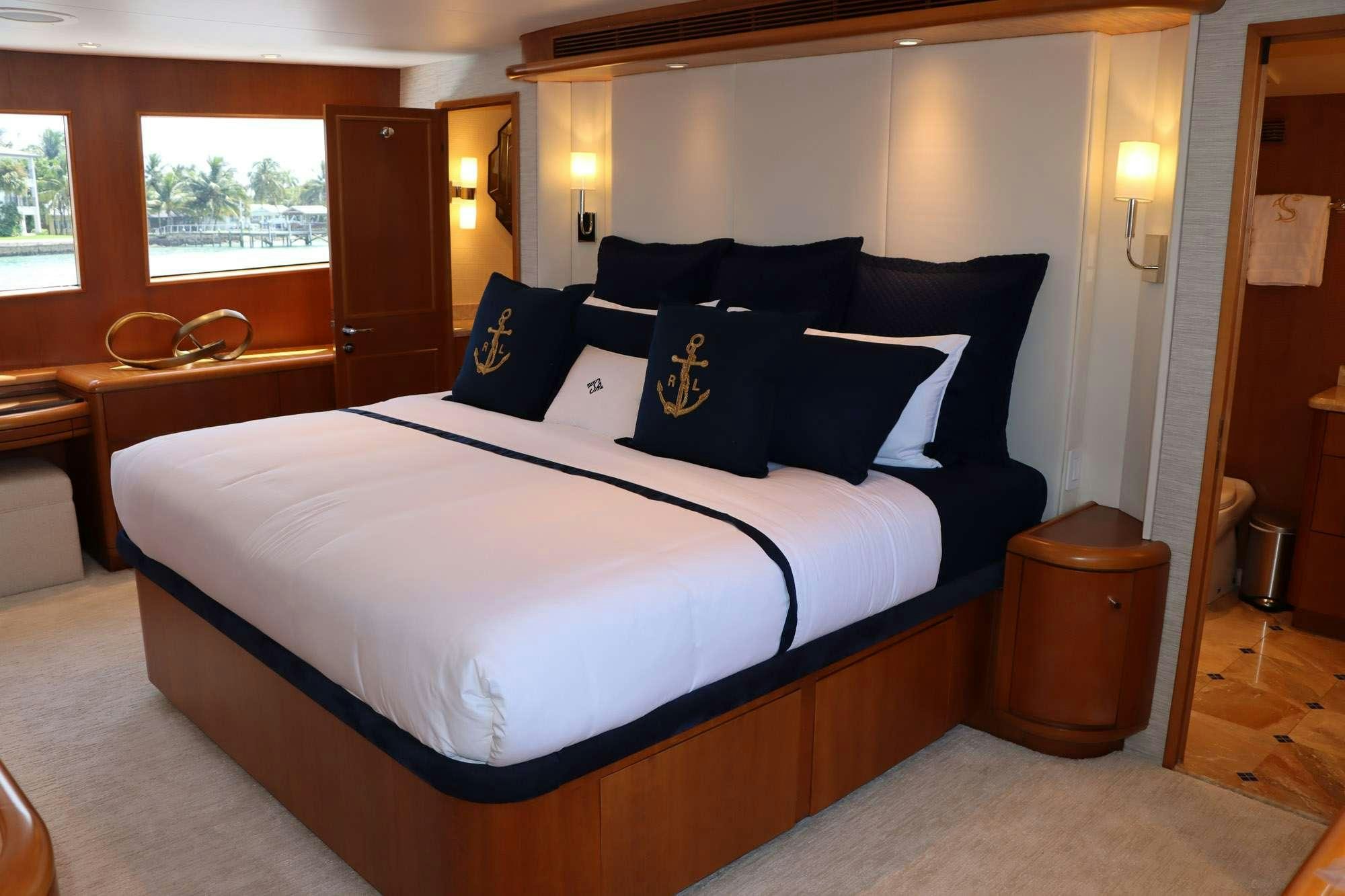 a bed with blue and white sheets aboard TOO SHALLOW Yacht for Charter