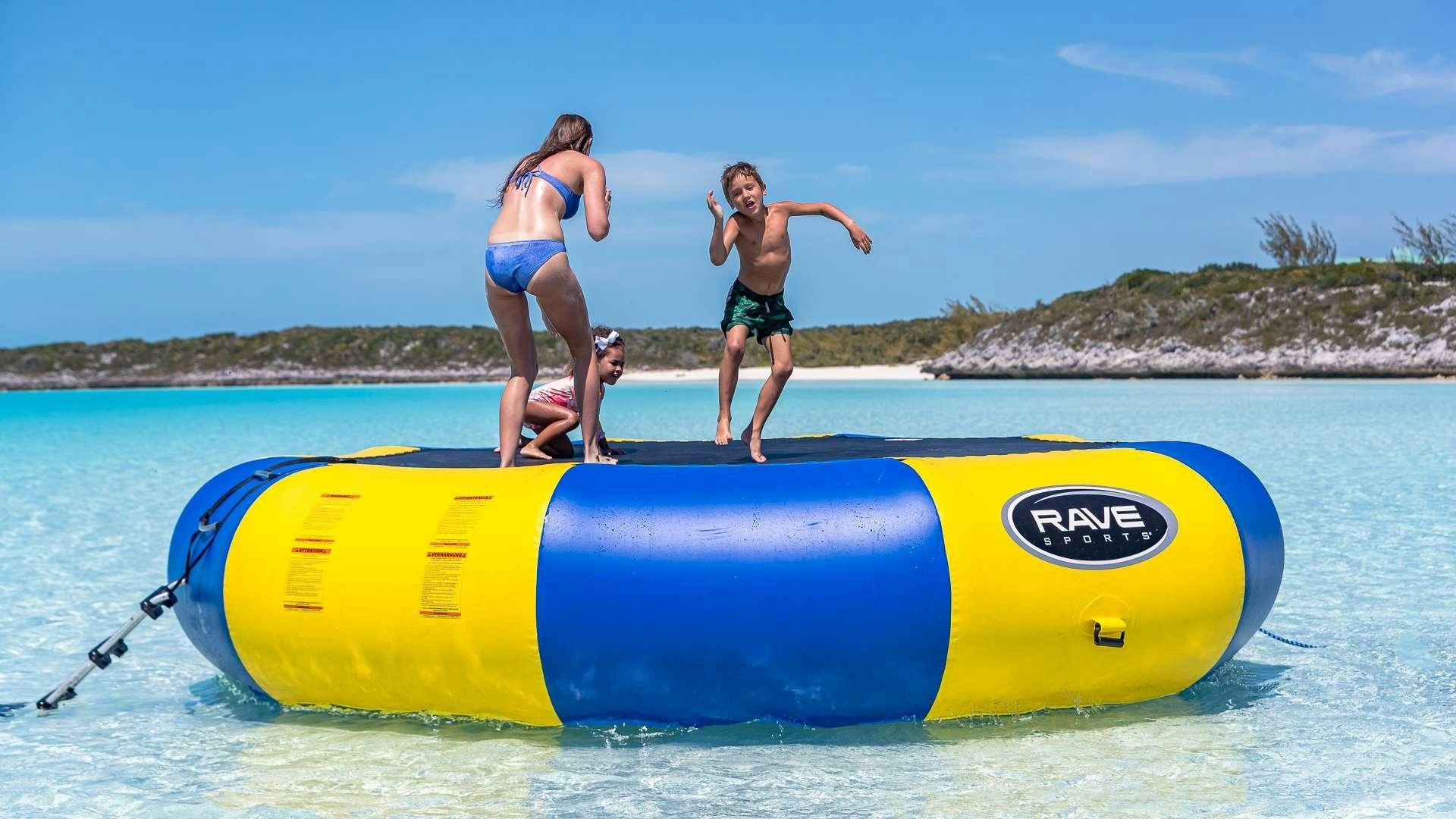 a person and two children on a raft in the water aboard STARSHIP Yacht for Charter