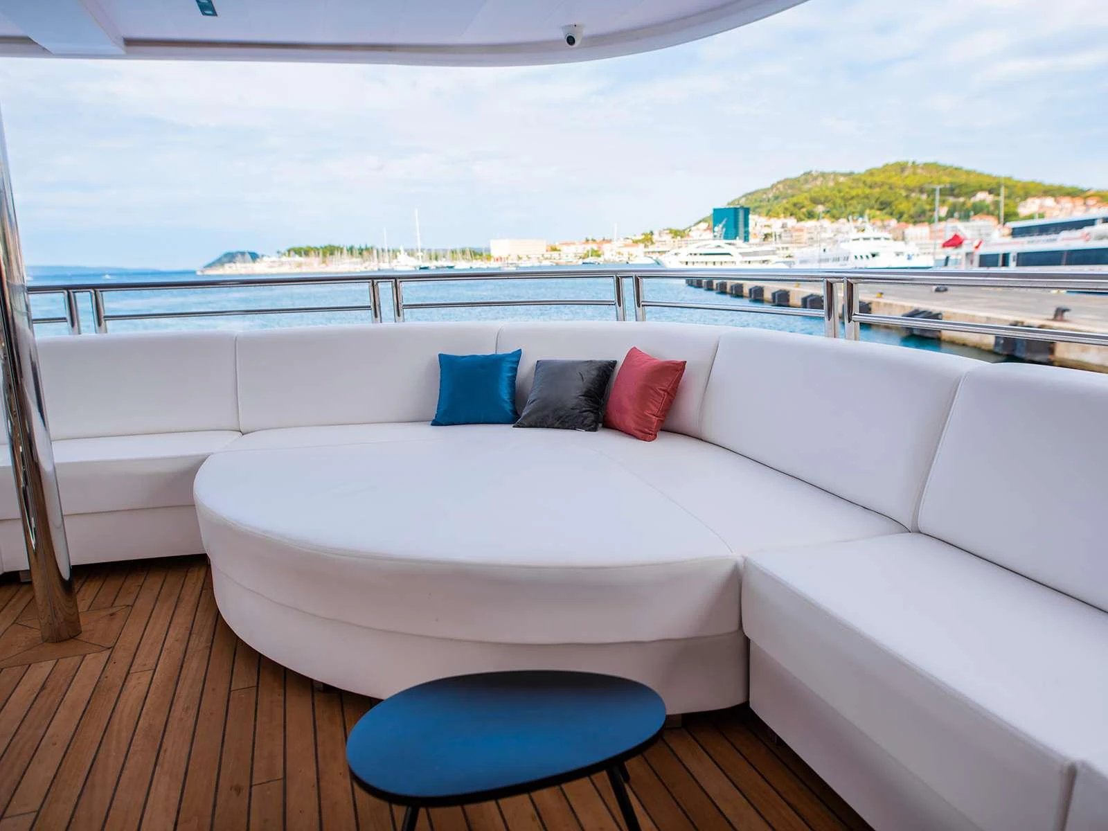 a white couch with pillows on a deck overlooking a body of water aboard ALFA MARIO Yacht for Charter
