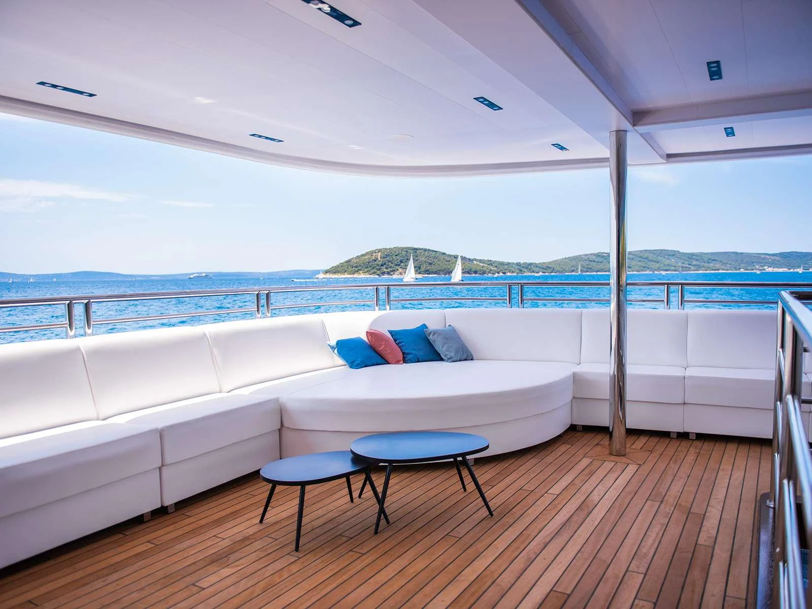 a large white bed with a table and chairs on a deck aboard ALFA MARIO Yacht for Charter
