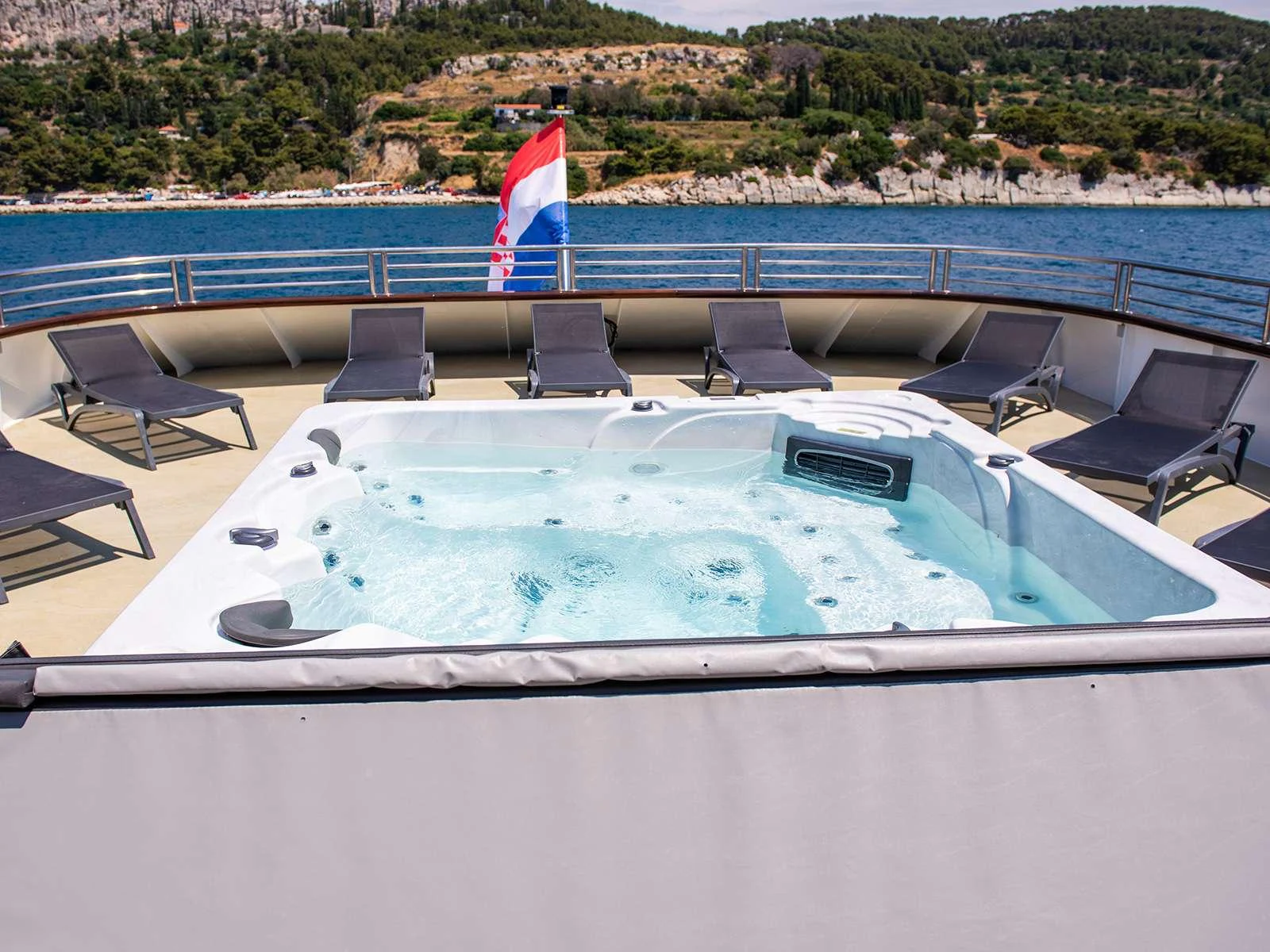 a boat with a flag on the front aboard ALFA MARIO Yacht for Charter