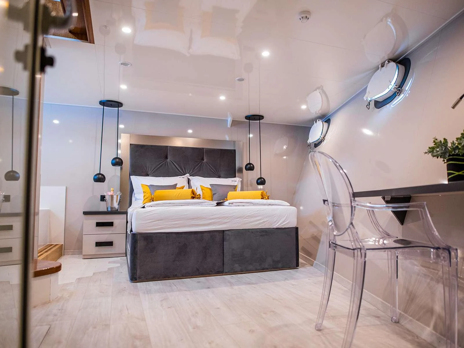 a bedroom with a bed and a chair aboard ALFA MARIO Yacht for Charter