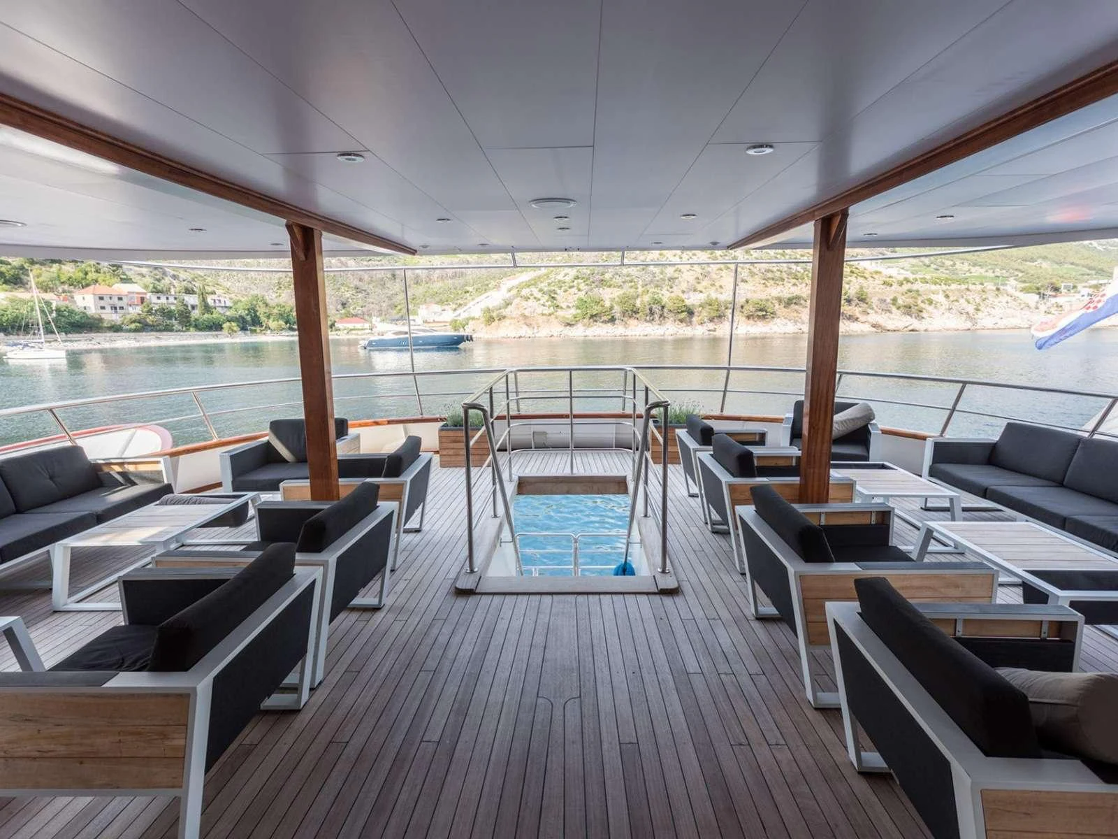 a room with a deck and chairs aboard KARIZMA Yacht for Charter