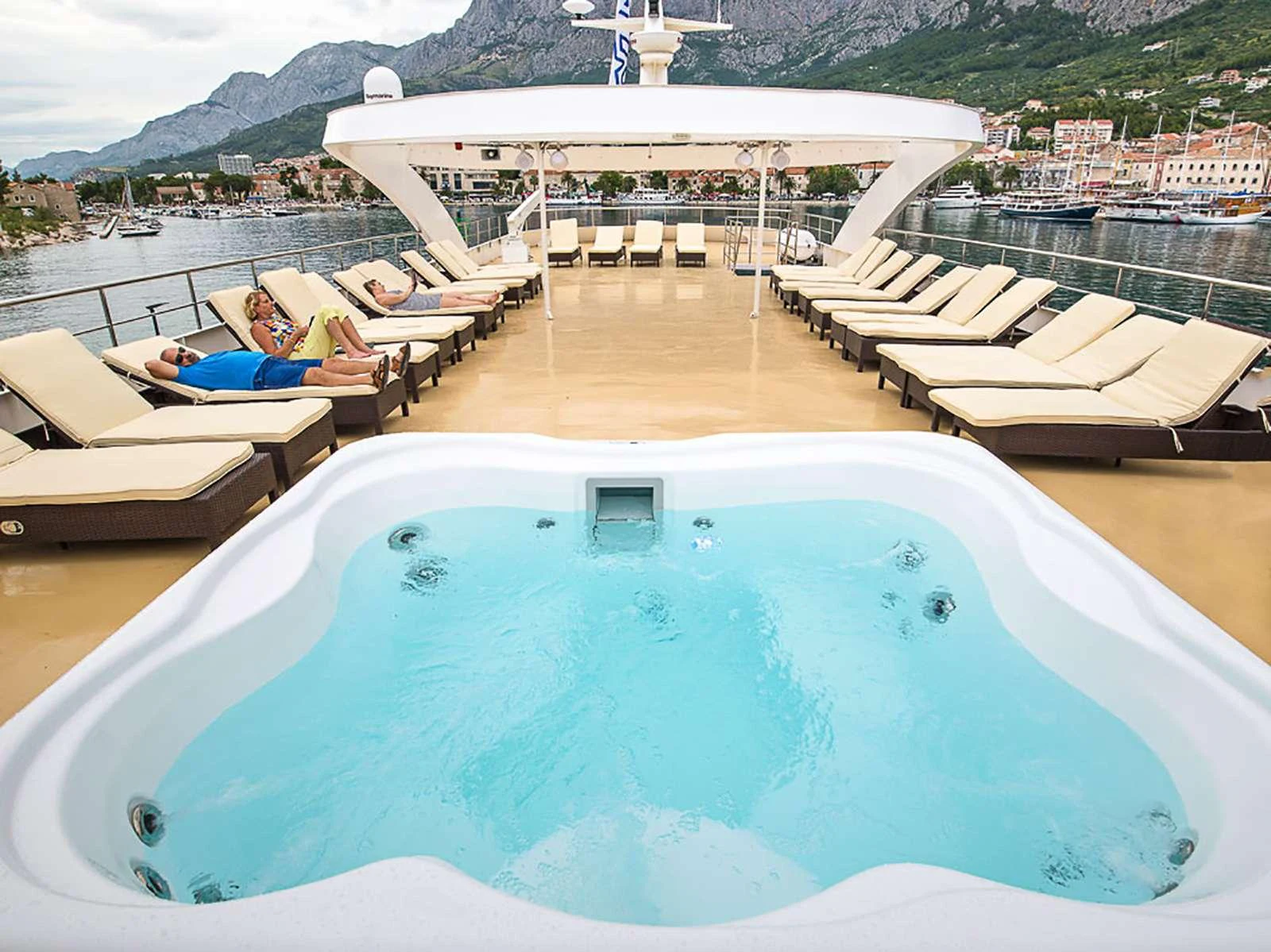 a person lying on a lounge chair on a lounge chair on a beach aboard KARIZMA Yacht for Charter