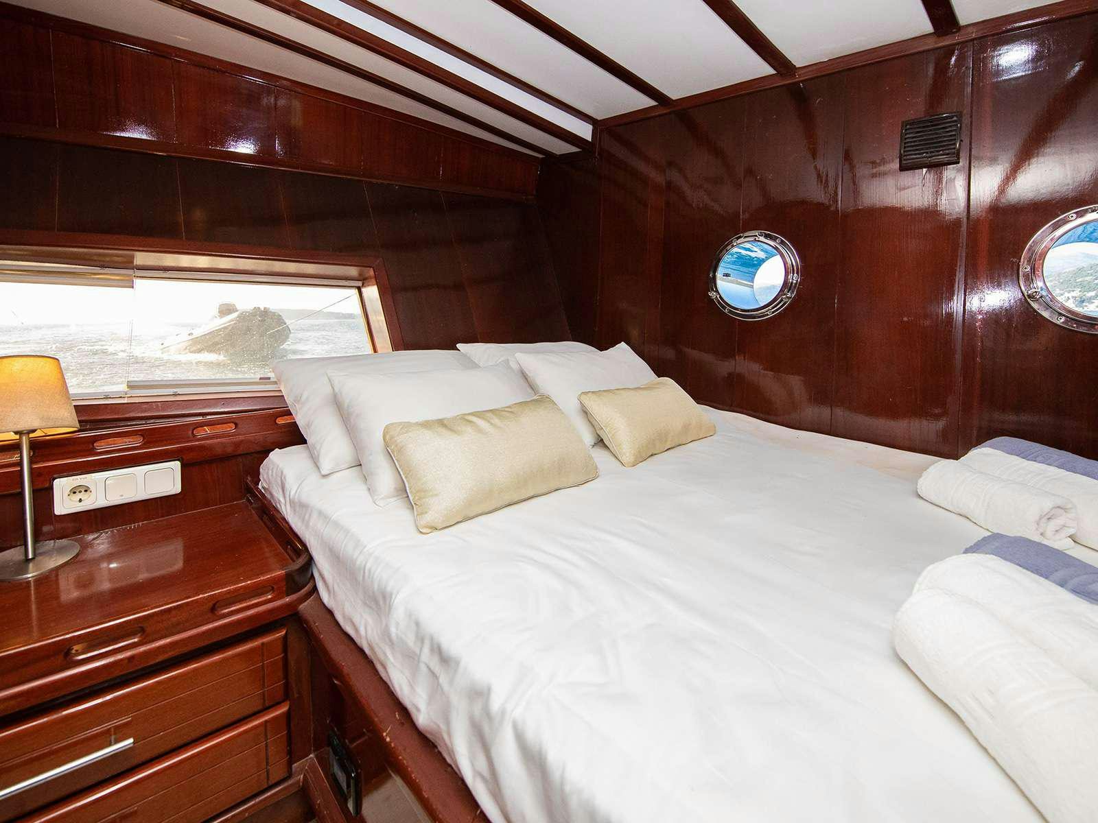 a bed with white sheets aboard DALMATINO Yacht for Charter