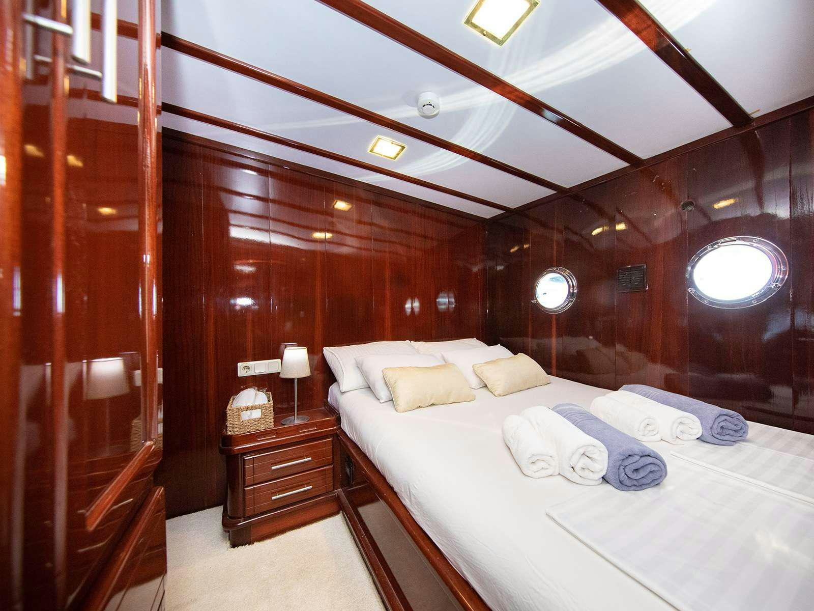 a room with a bed and a mirror aboard DALMATINO Yacht for Charter