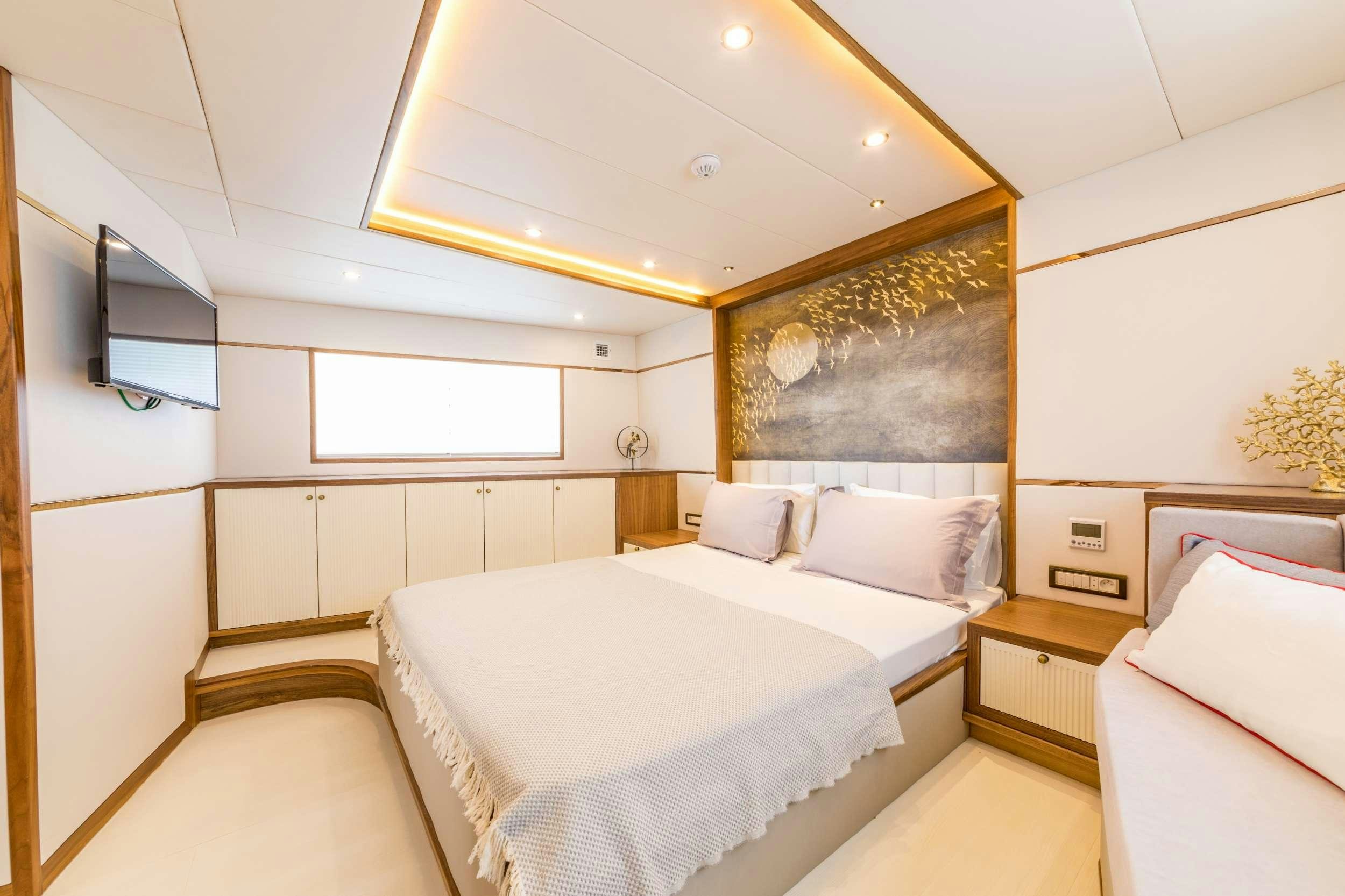 a room with a bed and a television aboard FLOKI Yacht for Charter