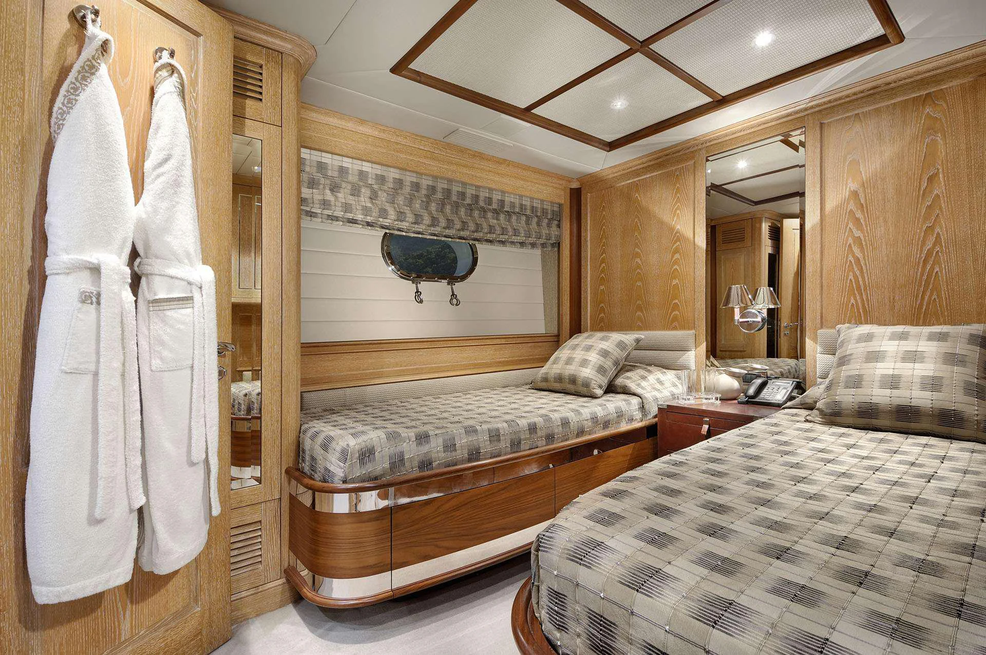 a bedroom with a bed and a mirror aboard QUEST R Yacht for Charter