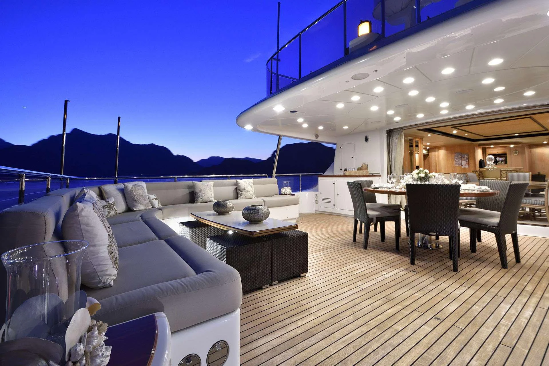 a large room with a table and chairs and a large mountain in the background aboard QUEST R Yacht for Charter