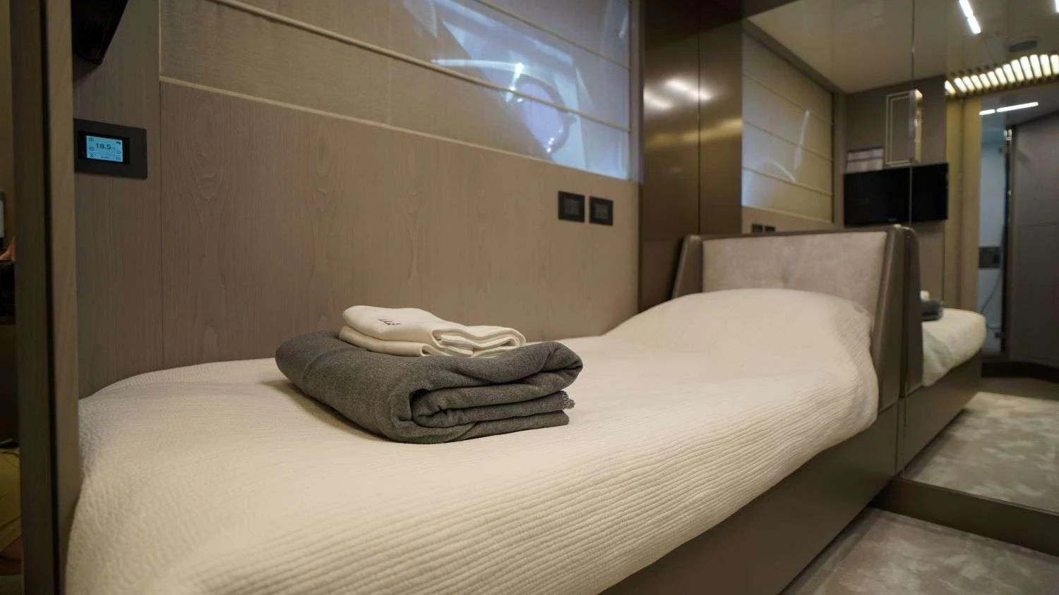 a room with a bed and a tv on the wall aboard SHERO Yacht for Charter
