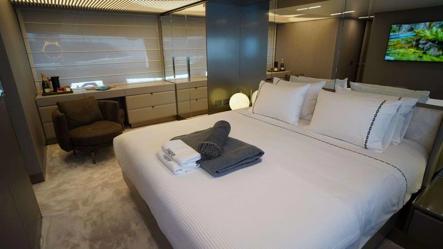 a hotel room with a bed and a chair aboard SHERO Yacht for Charter