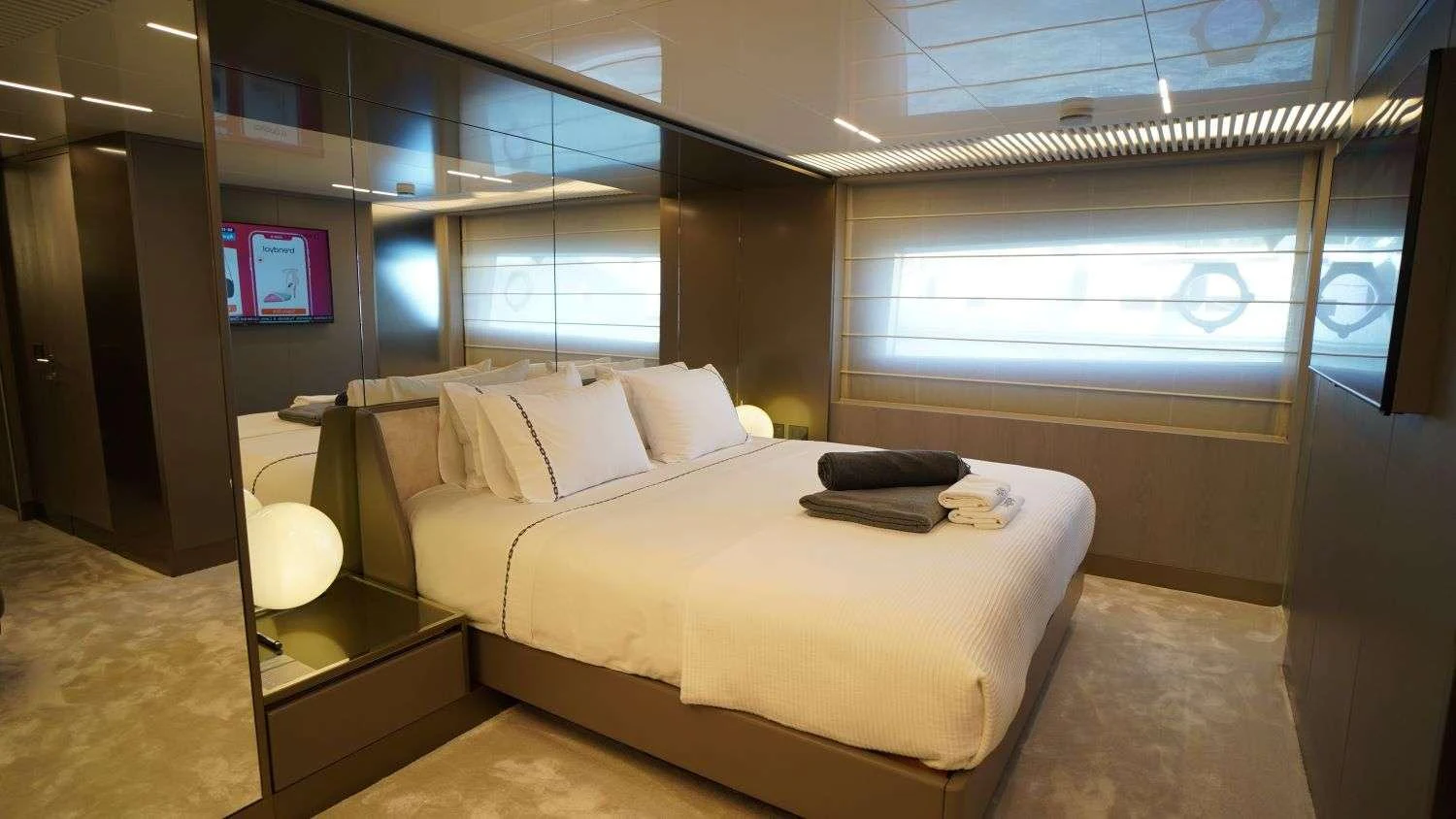 a room with a bed and a tv on the wall aboard SHERO Yacht for Charter