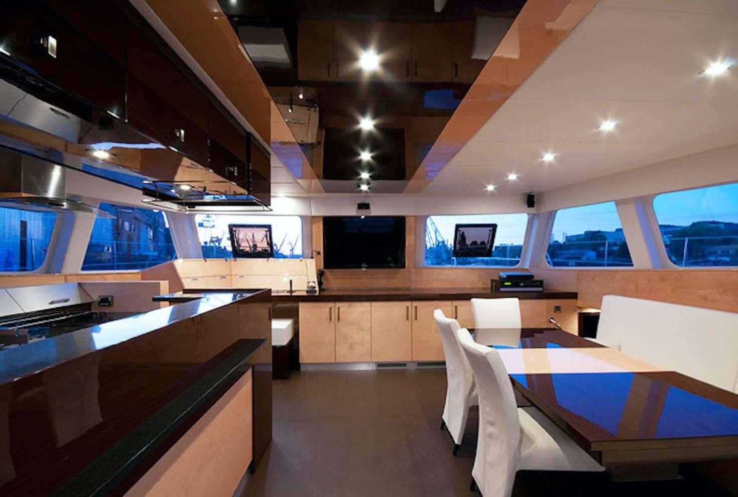 a room with a table chairs and a tv aboard SERENDIPITY Yacht for Charter