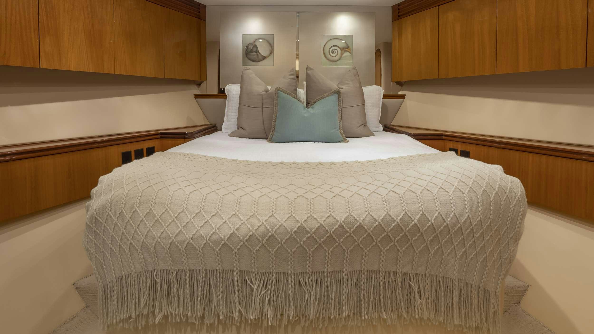 a bed with white sheets and pillows aboard GALLOPIN Yacht for Charter