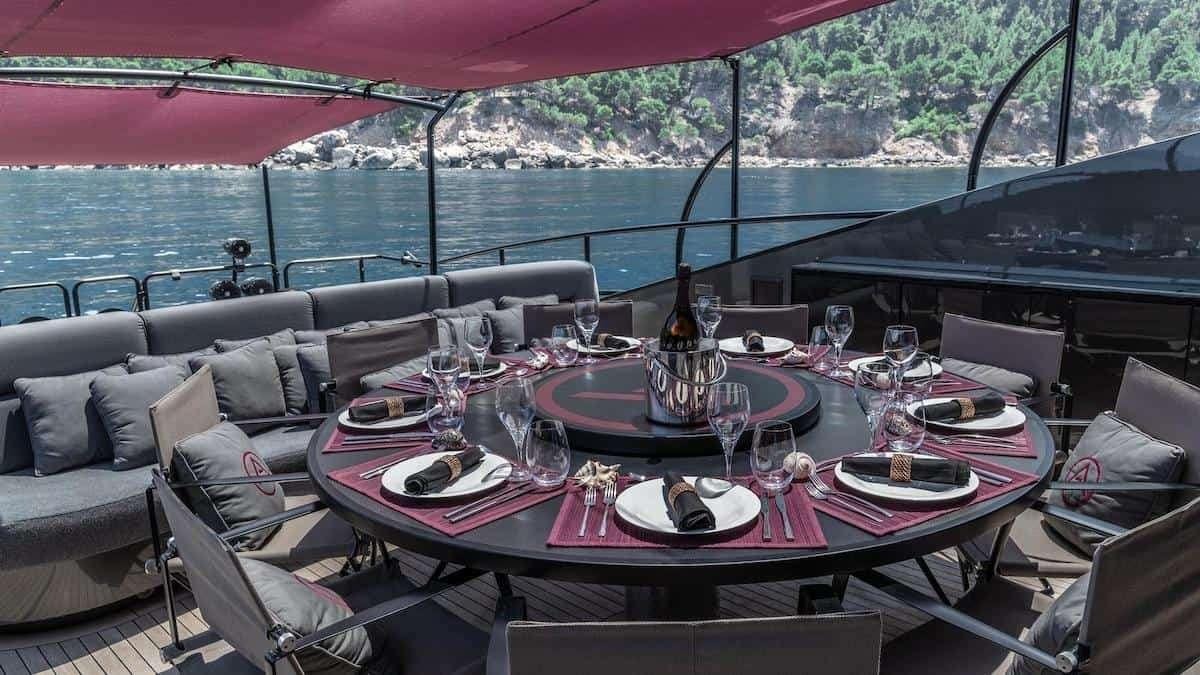a table set with plates and glasses aboard SETTE Yacht for Charter