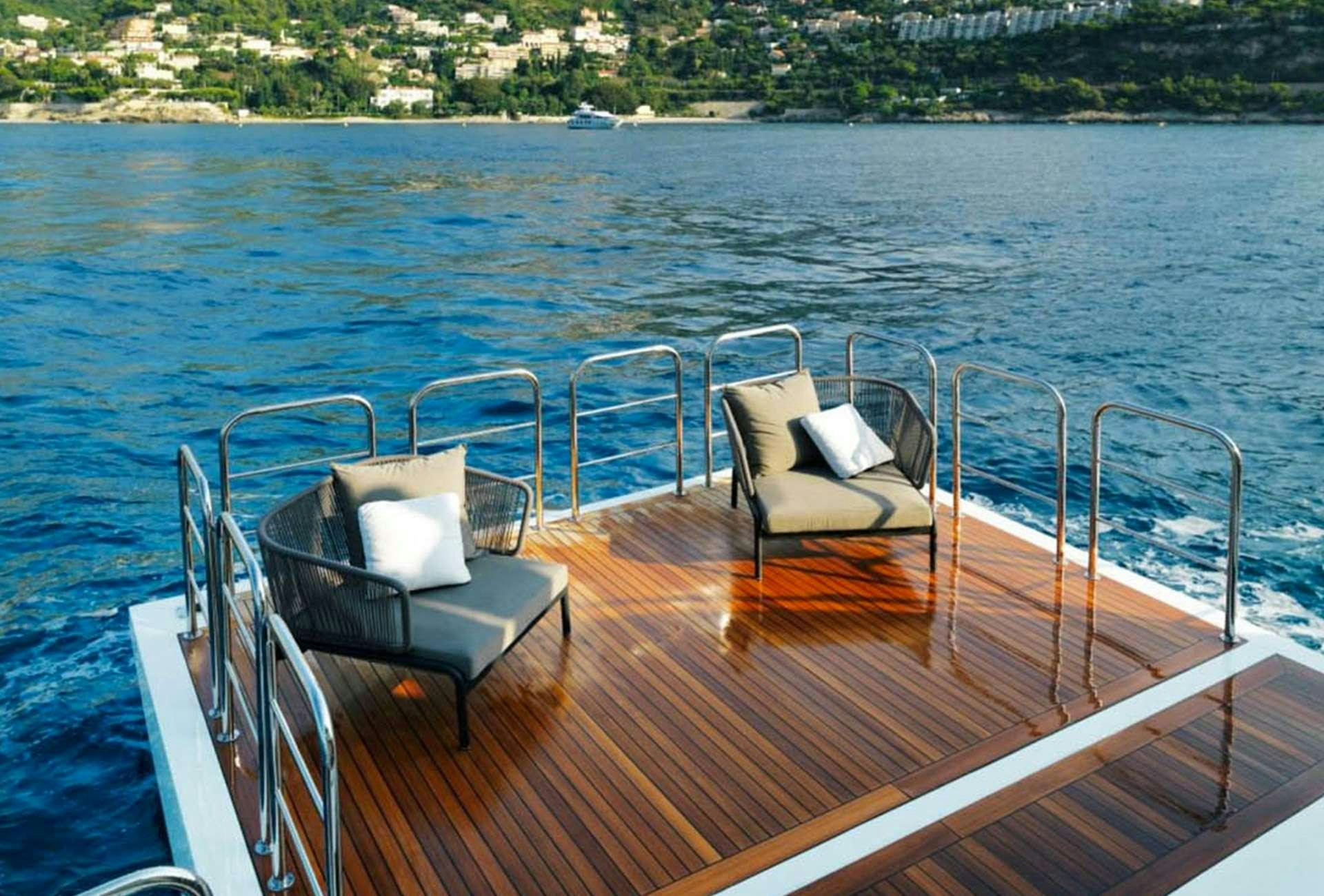 a deck with chairs on it by a body of water aboard LEUDIN I Yacht for Charter