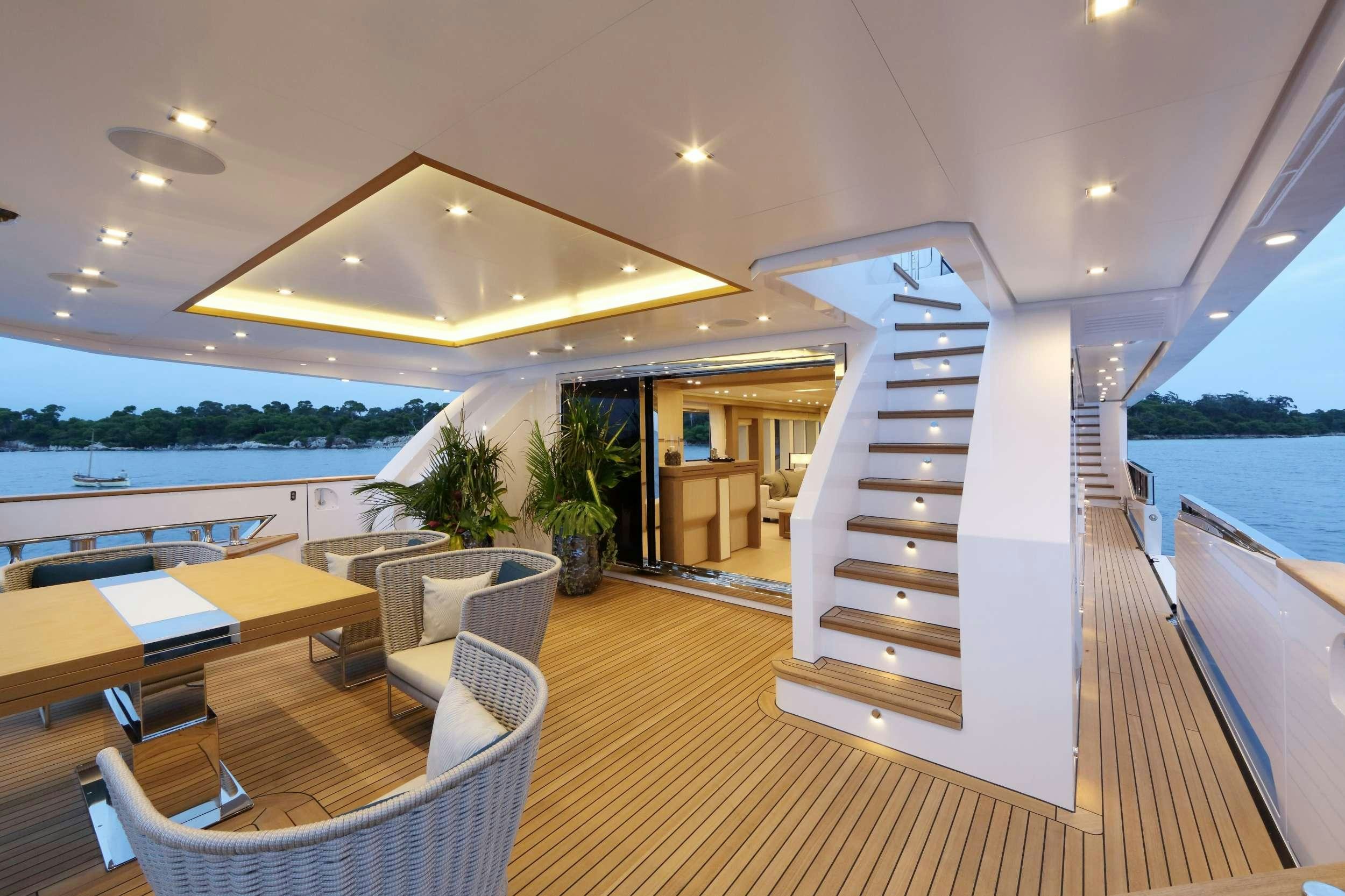 a room with a staircase and chairs aboard LEUDIN I Yacht for Charter