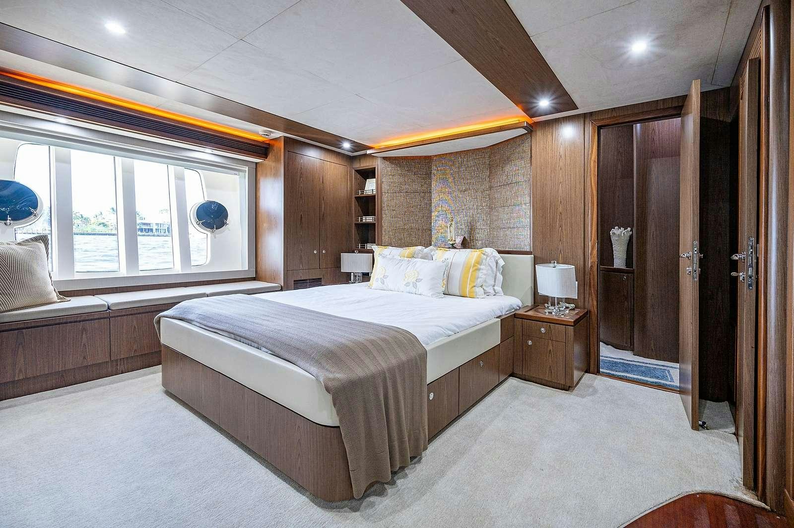 a bedroom with a bed and a window aboard THE LIFE  Yacht for Charter