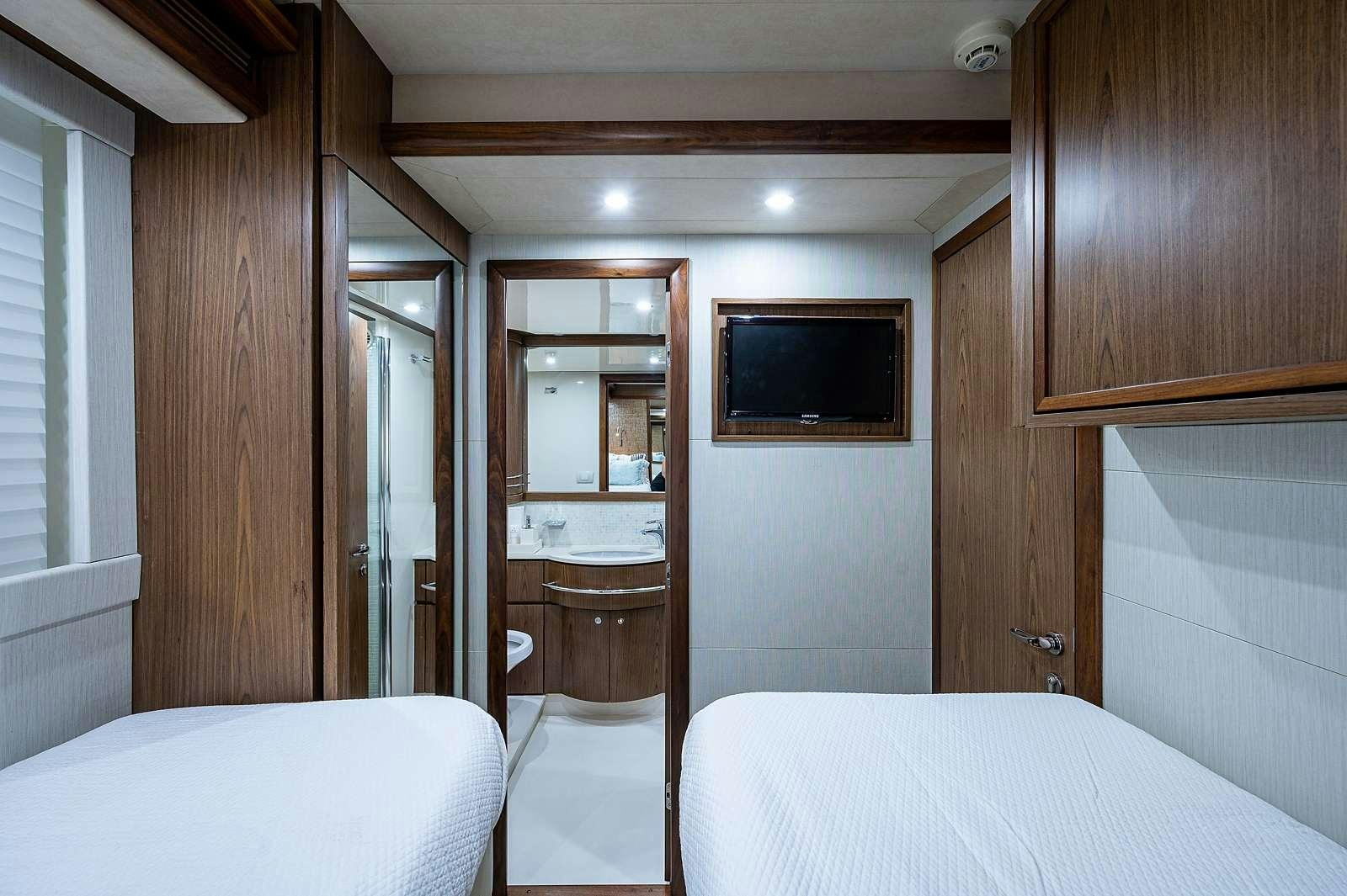 a bedroom with a bed and a television aboard THE LIFE  Yacht for Charter