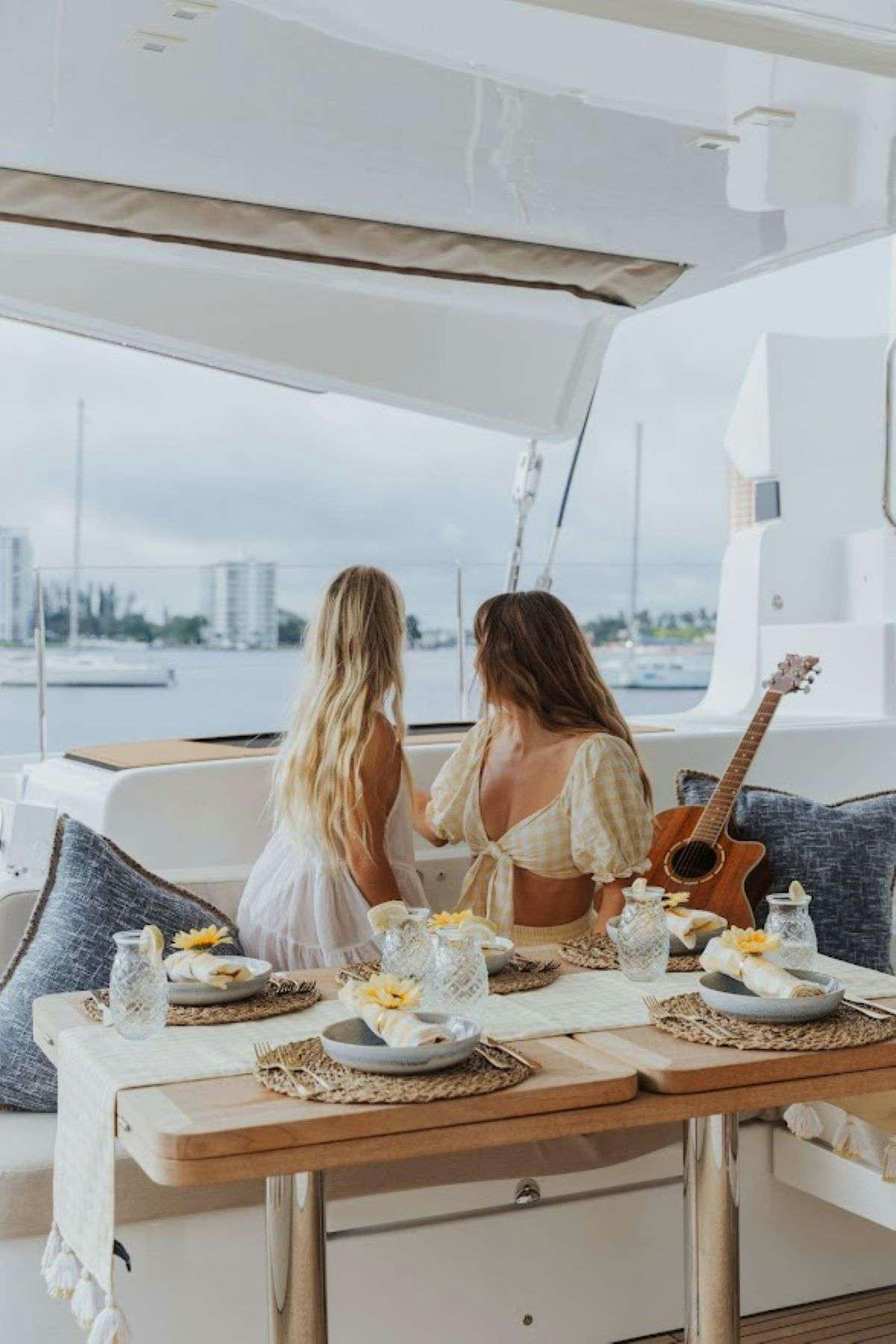 a couple of women sitting at a table with food on it aboard Purely Blu Yacht for Charter