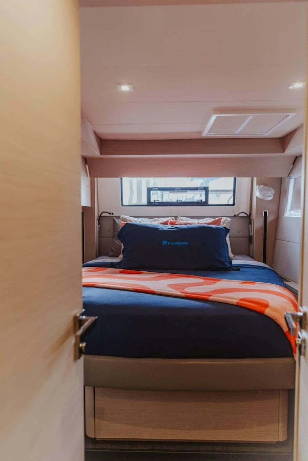 a bed with a striped blanket aboard Purely Blu Yacht for Charter