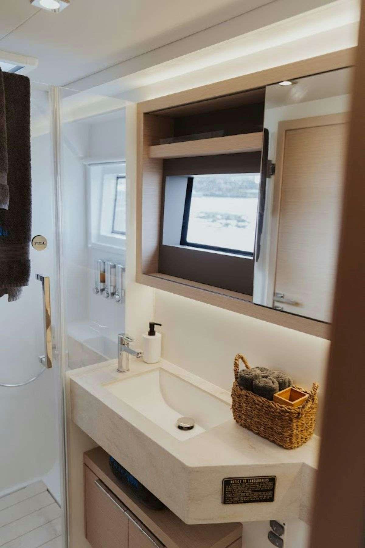 a bathroom with a sink and a mirror aboard Purely Blu Yacht for Charter