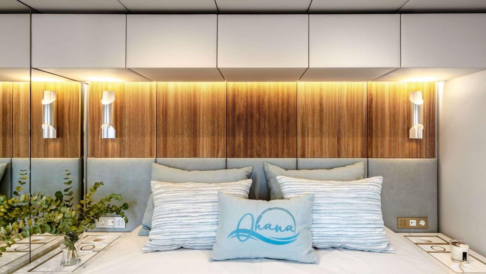 a bed with white pillows aboard OHANA Yacht for Charter