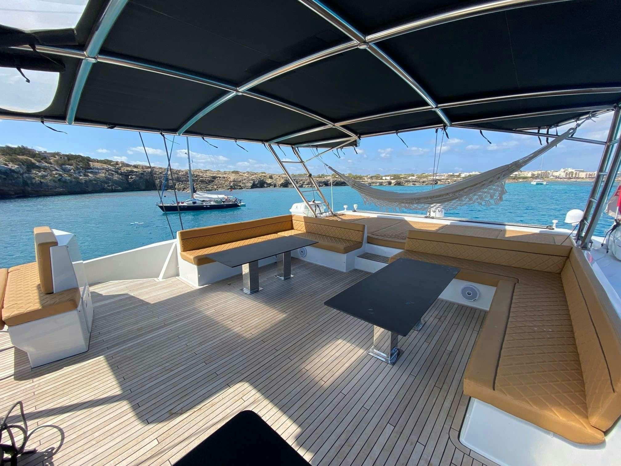 a deck with a view of the water and boats in the background aboard MOON DRAGON Yacht for Charter