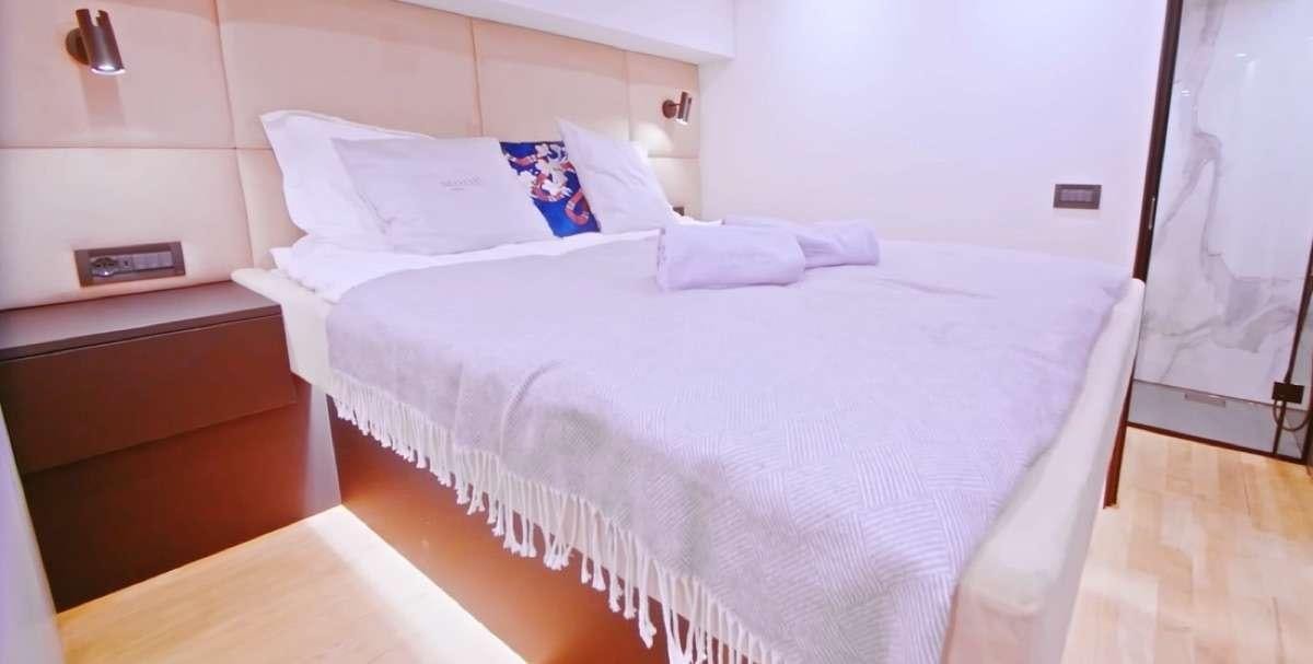 a bed with white sheets aboard MOON DRAGON Yacht for Charter