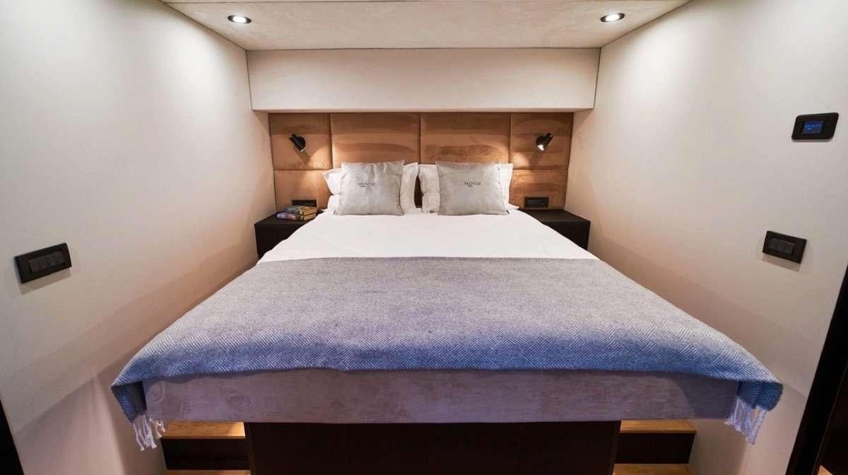 a bed with a purple sheet aboard MOON DRAGON Yacht for Charter