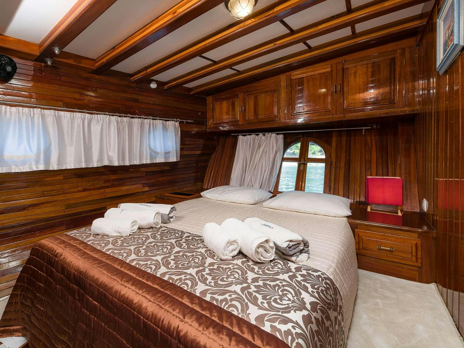 a room with a bed and a window aboard GULET CROATIA Yacht for Charter
