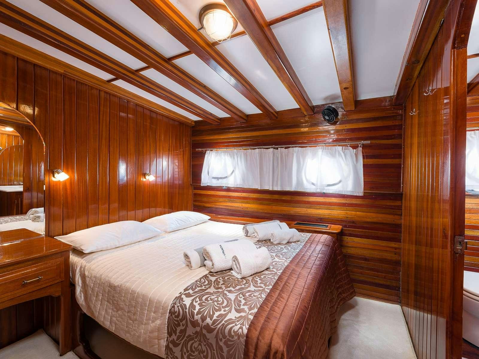 a room with a bed and a wood wall aboard GULET CROATIA Yacht for Charter