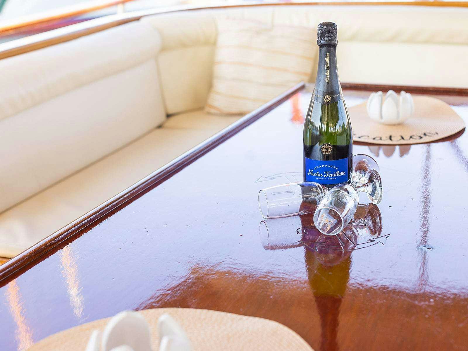 a bottle of wine and glasses on a table aboard Gulet Gardelin Yacht for Charter