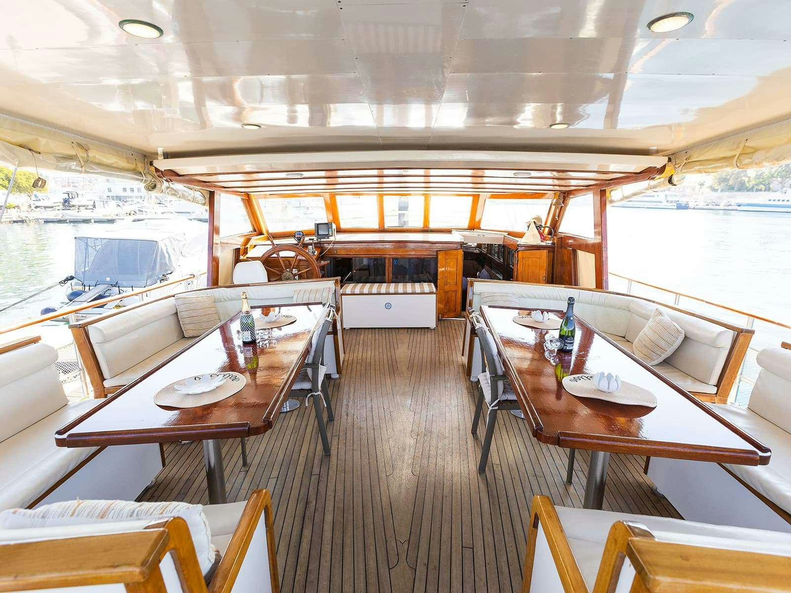 a room with tables and chairs aboard Gulet Gardelin Yacht for Charter
