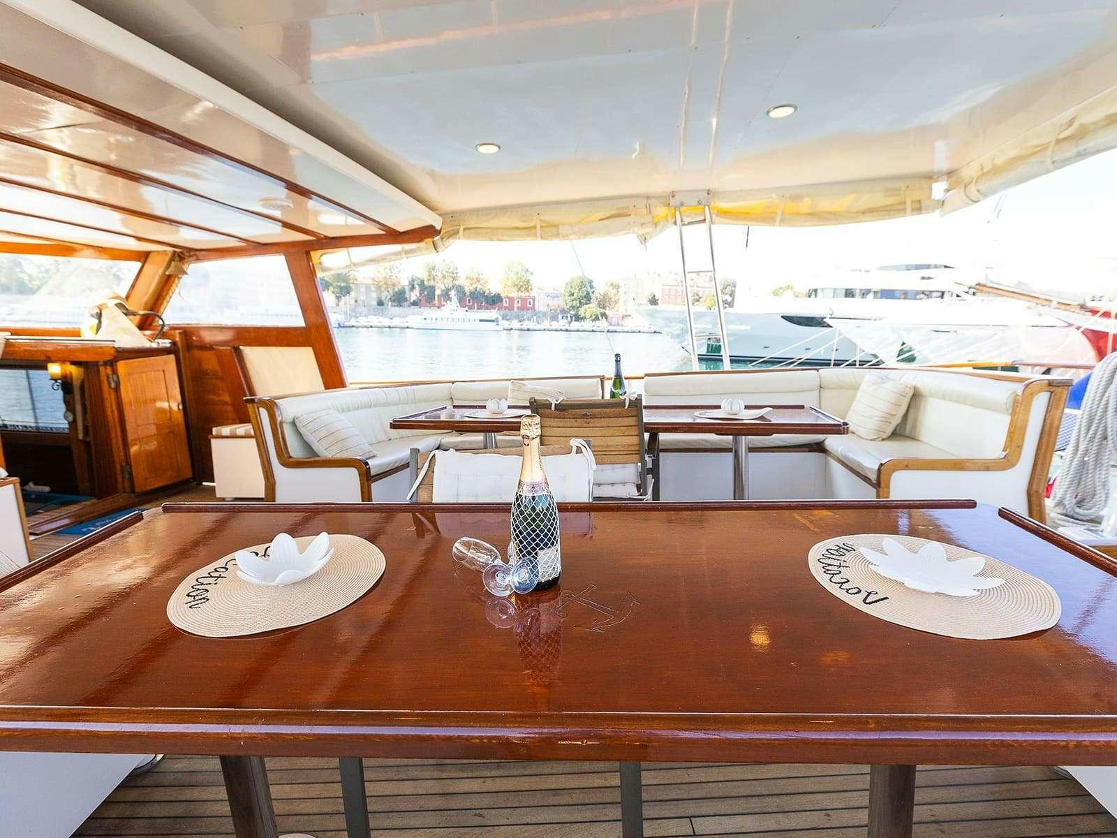 a table with plates and bottles on it aboard Gulet Gardelin Yacht for Charter