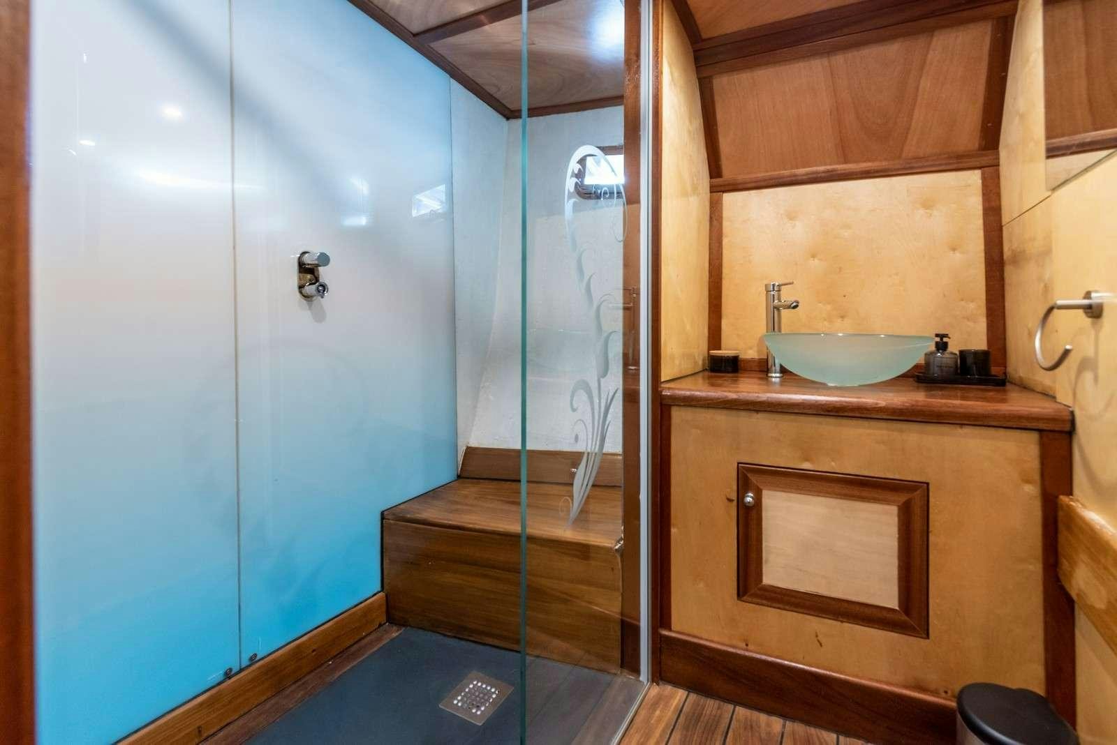 a bathroom with a shower and sink aboard Trebenna Yacht for Charter