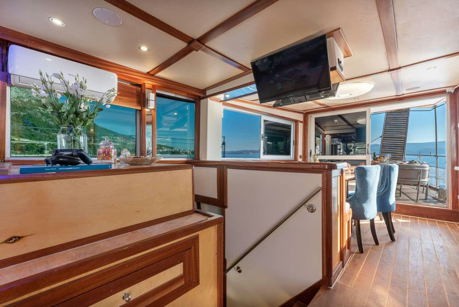 a kitchen with a tv on the wall aboard Trebenna Yacht for Charter