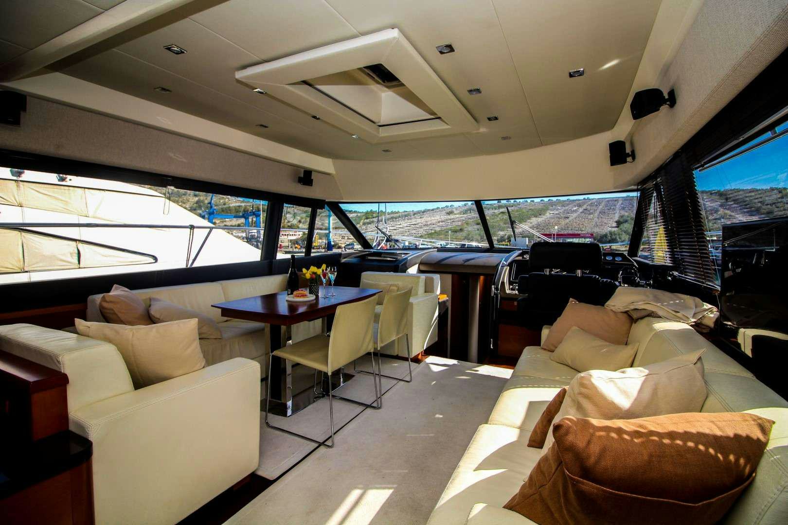 a room with a couch and a table and a television aboard GRACE Yacht for Charter