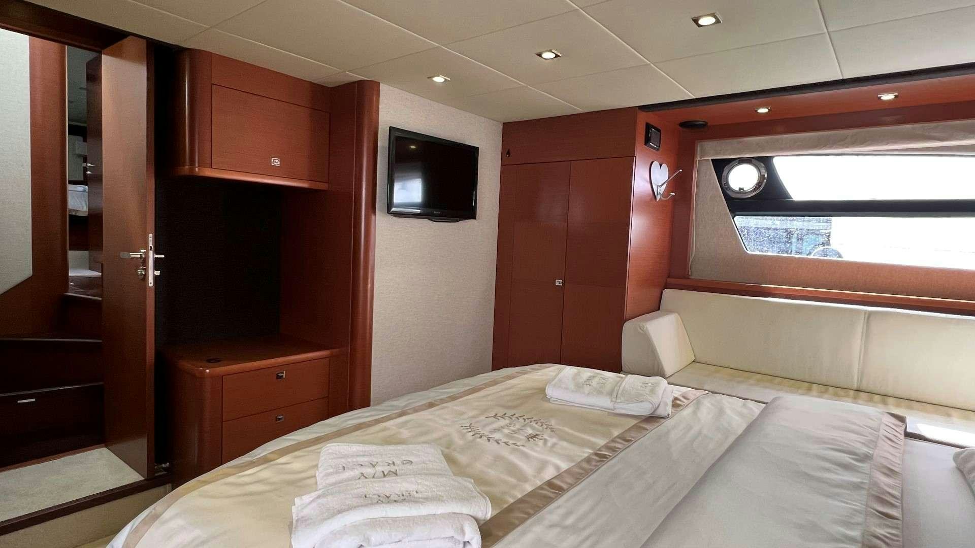 a room with a bed and tv aboard GRACE Yacht for Charter