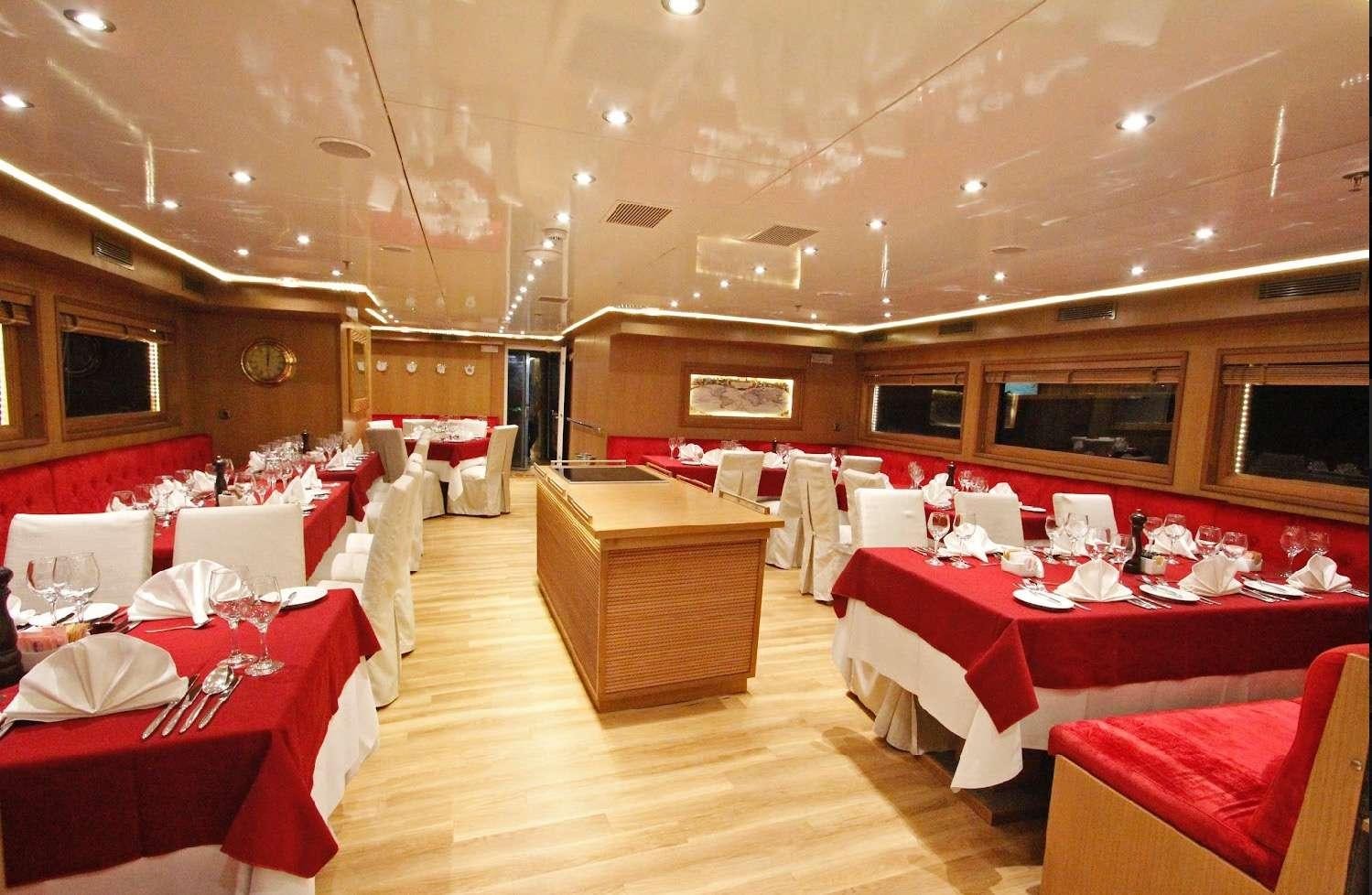 a room with tables and chairs aboard HARMONY Yacht for Charter