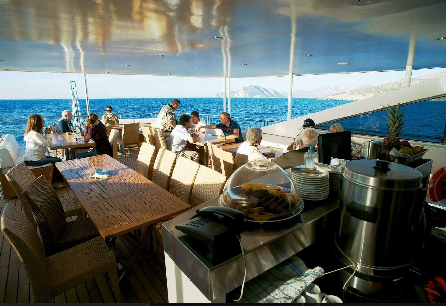 people sitting at tables on a boat aboard HARMONY Yacht for Charter