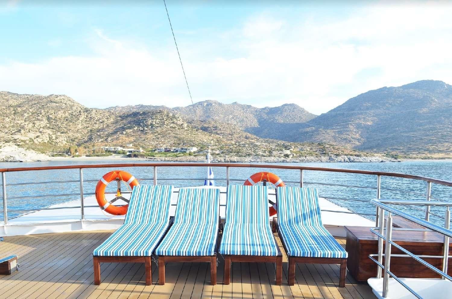 a deck with chairs on it by the water aboard CALLISTO Yacht for Charter
