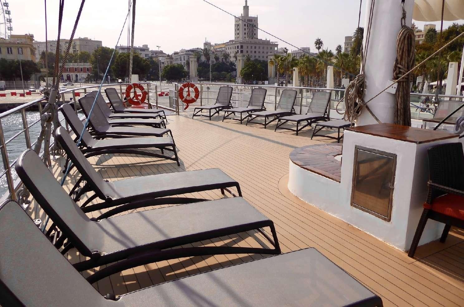a group of black and white chairs on a deck overlooking a city aboard PAN ORAMA II Yacht for Charter